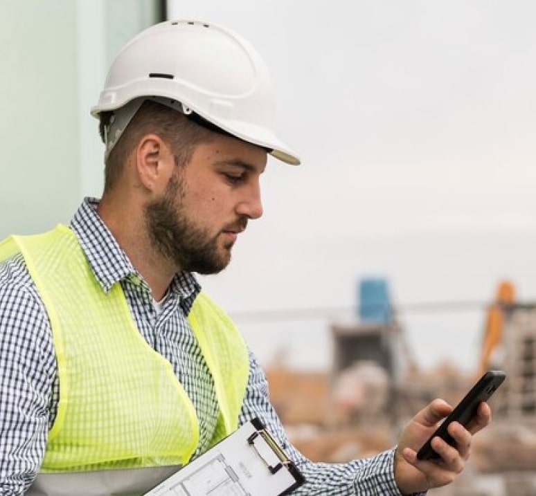 Site engineer checking compliance data on a phone