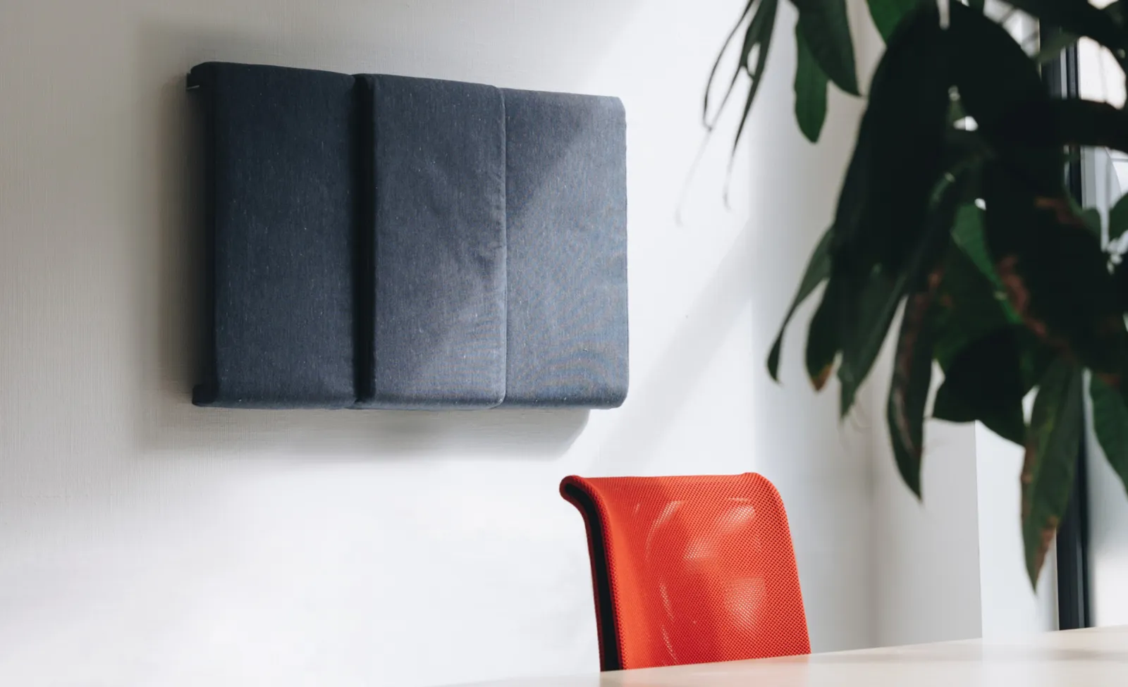 Dark grey recycled acoustic sound panels mounted on a white wall